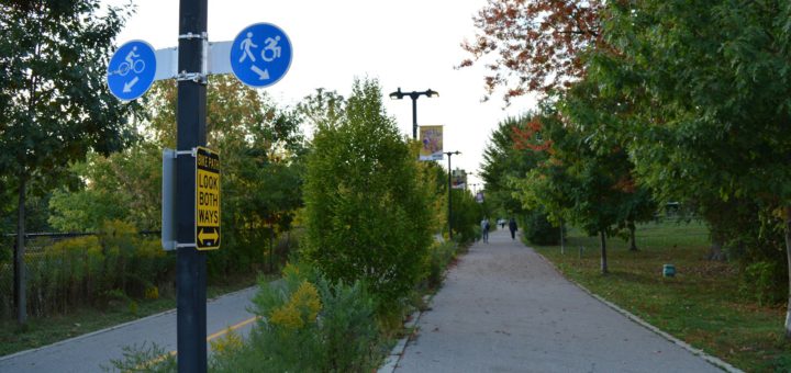 Značení stezky pro pěší a cyklisty u cesty mezi stromy
