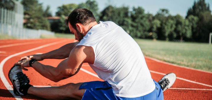 Sportovec při protažení na atletické dráze